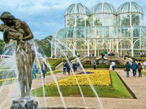 imagem do Jardim botânico de Curitiba com pessoas andando por ele